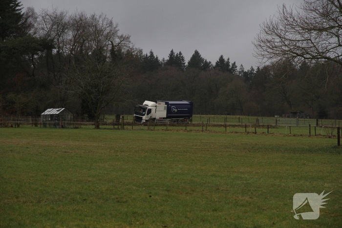 Vuilniswagen raakt paal en blijft vastzitten