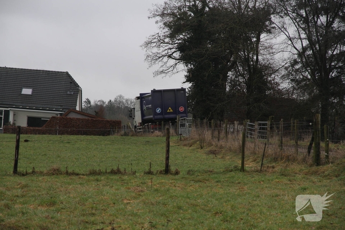 Vuilniswagen raakt paal en blijft vastzitten