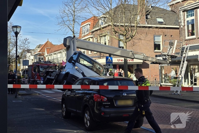 Hoogwerker kantelt tegen winkelpand