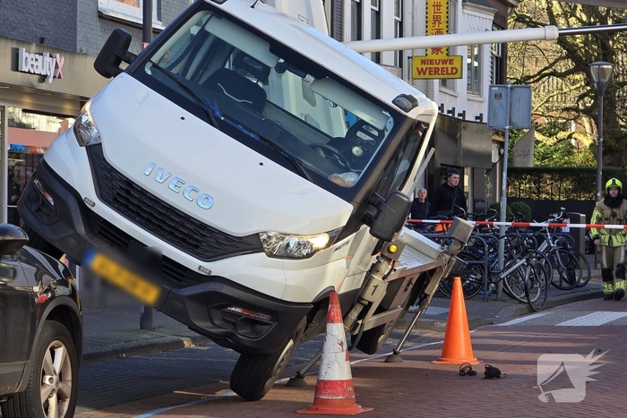 Hoogwerker kantelt tegen winkelpand