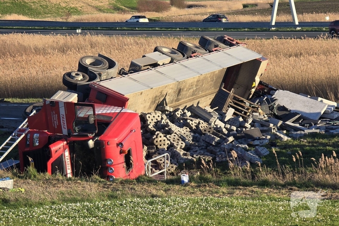 Vrachtwagen met betonblokken kantelt