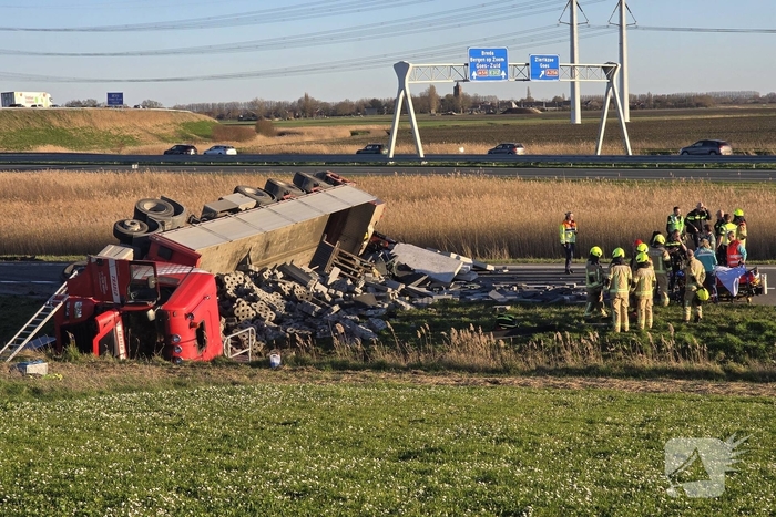 Vrachtwagen met betonblokken kantelt