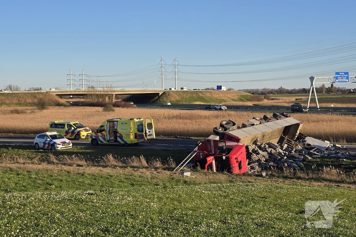 Vrachtwagen met betonblokken kantelt