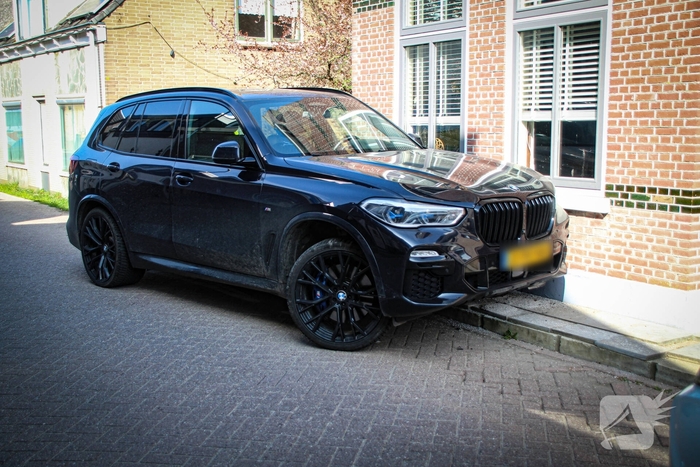 Auto botst tegen woning na aanrijding met paal