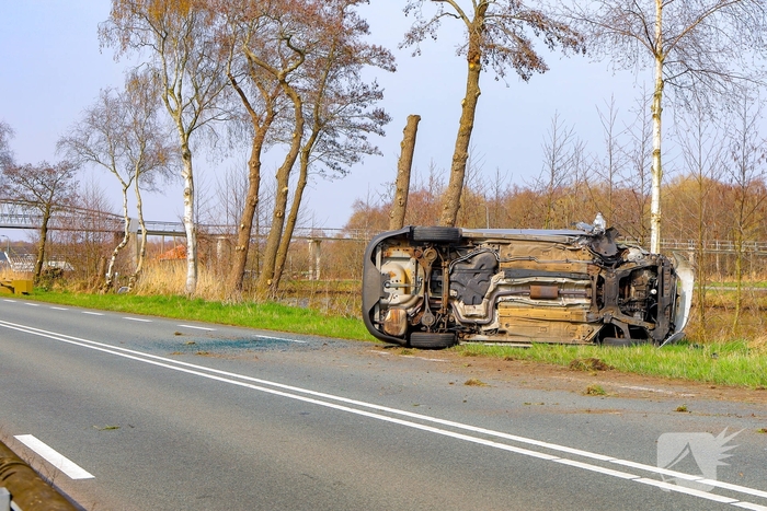 Auto belandt op zijn kant na botsing met boom