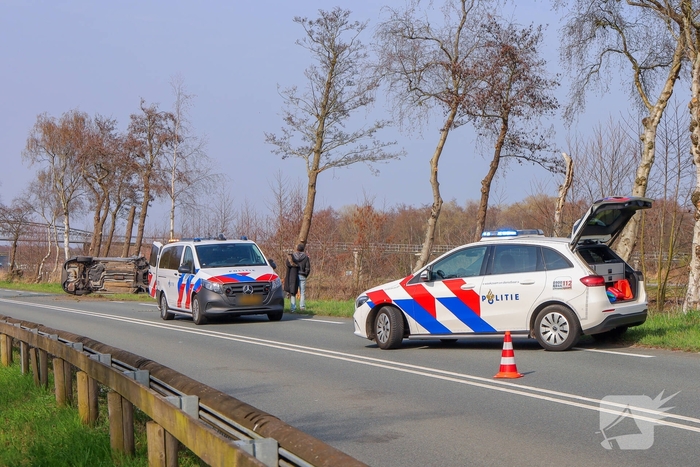 Auto belandt op zijn kant na botsing met boom