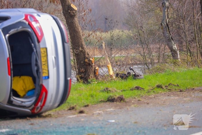 Auto belandt op zijn kant na botsing met boom