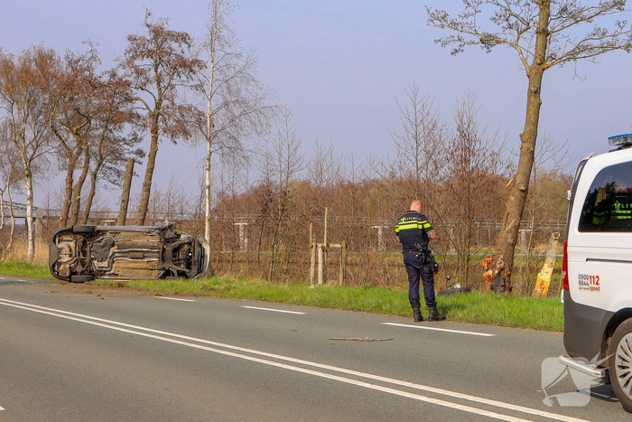Auto belandt op zijn kant na botsing met boom