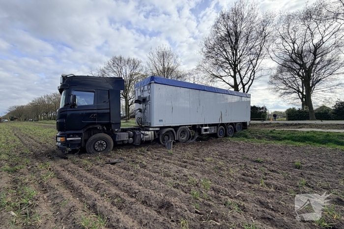 Vrachtwagen ramt auto en belandt in weiland