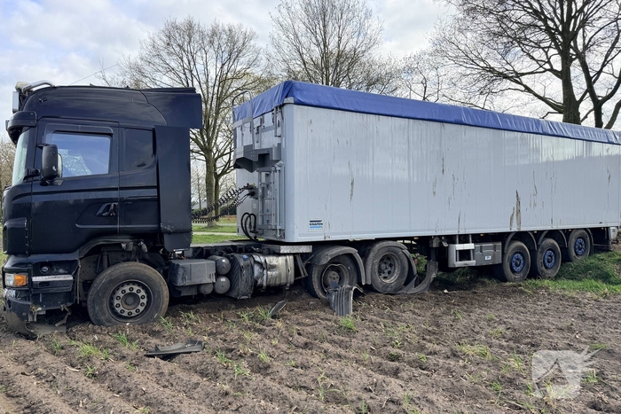 Vrachtwagen ramt auto en belandt in weiland