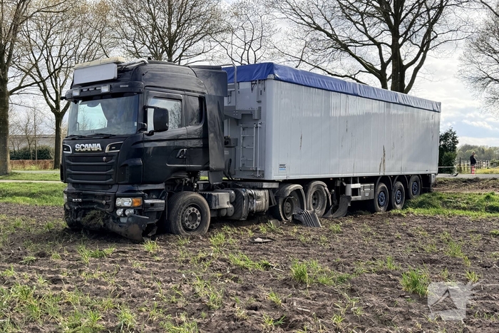 Vrachtwagen ramt auto en belandt in weiland