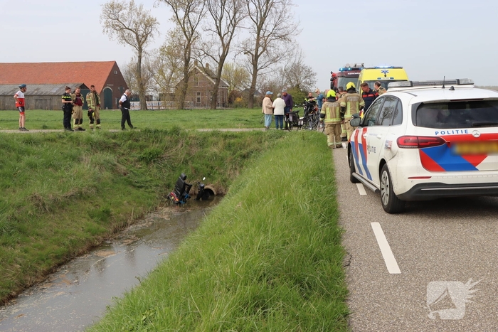 Persoon te water met scootmobiel