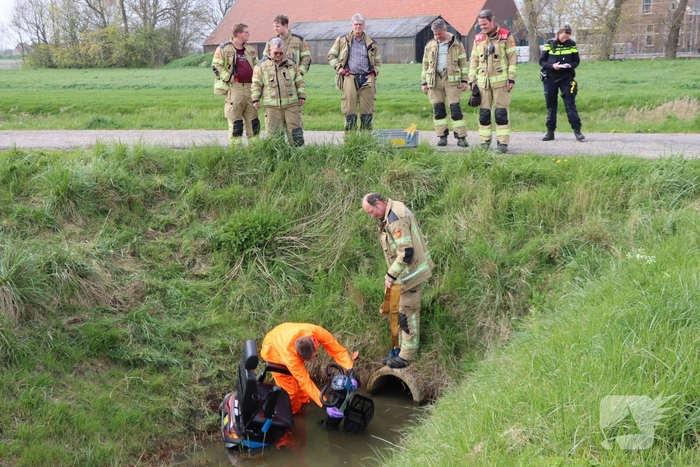 Persoon te water met scootmobiel