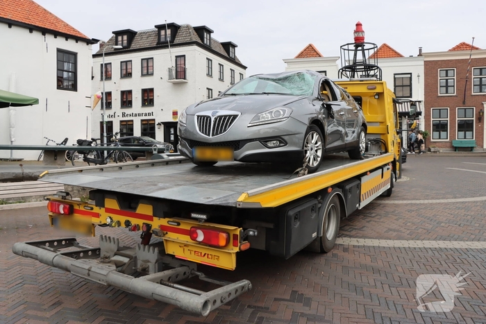 Auto op de kop op steiger na vergeten handrem
