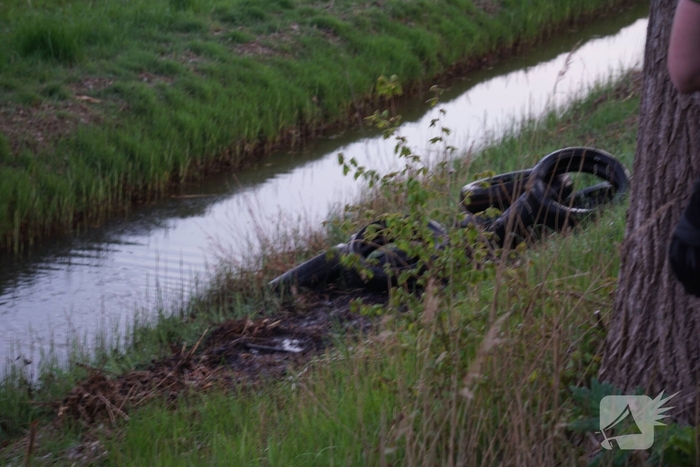 Autobanden in berm in brand gestoken