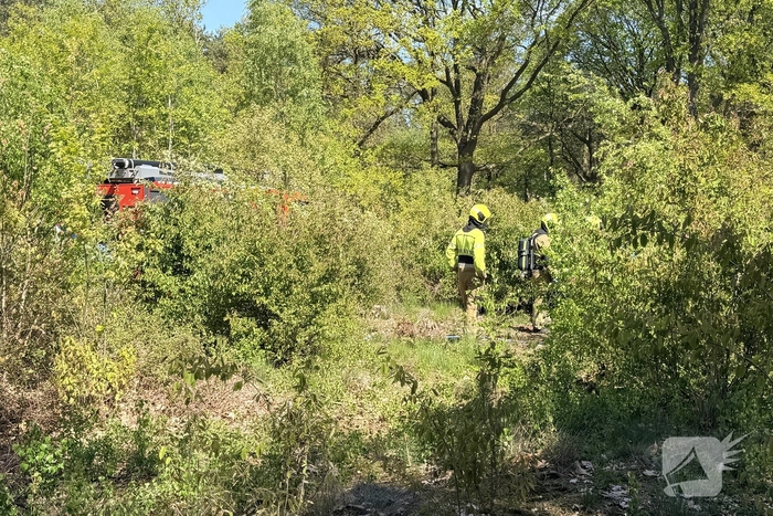 Brandweer blust buitenbrand in bos