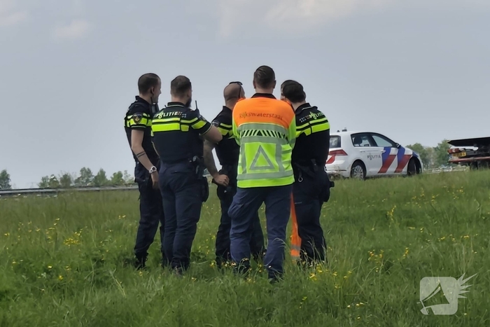Auto belandt op zijkant in sloot naast snelweg