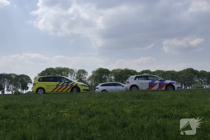 Auto belandt op zijkant in sloot naast snelweg