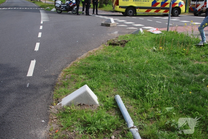 Omstanders halen inzittenden uit te water geraakt voertuig