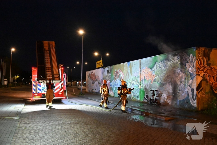 Scooter in brand naast opslag bij Kwik Fit