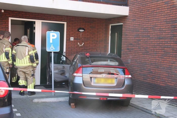 Automobilist ramt muur van appartementencomplex