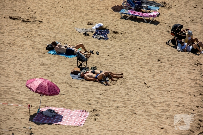 Mensen zoeken verkoeling aan zee