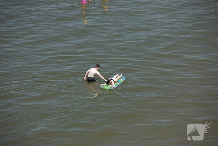 Mensen zoeken verkoeling aan zee
